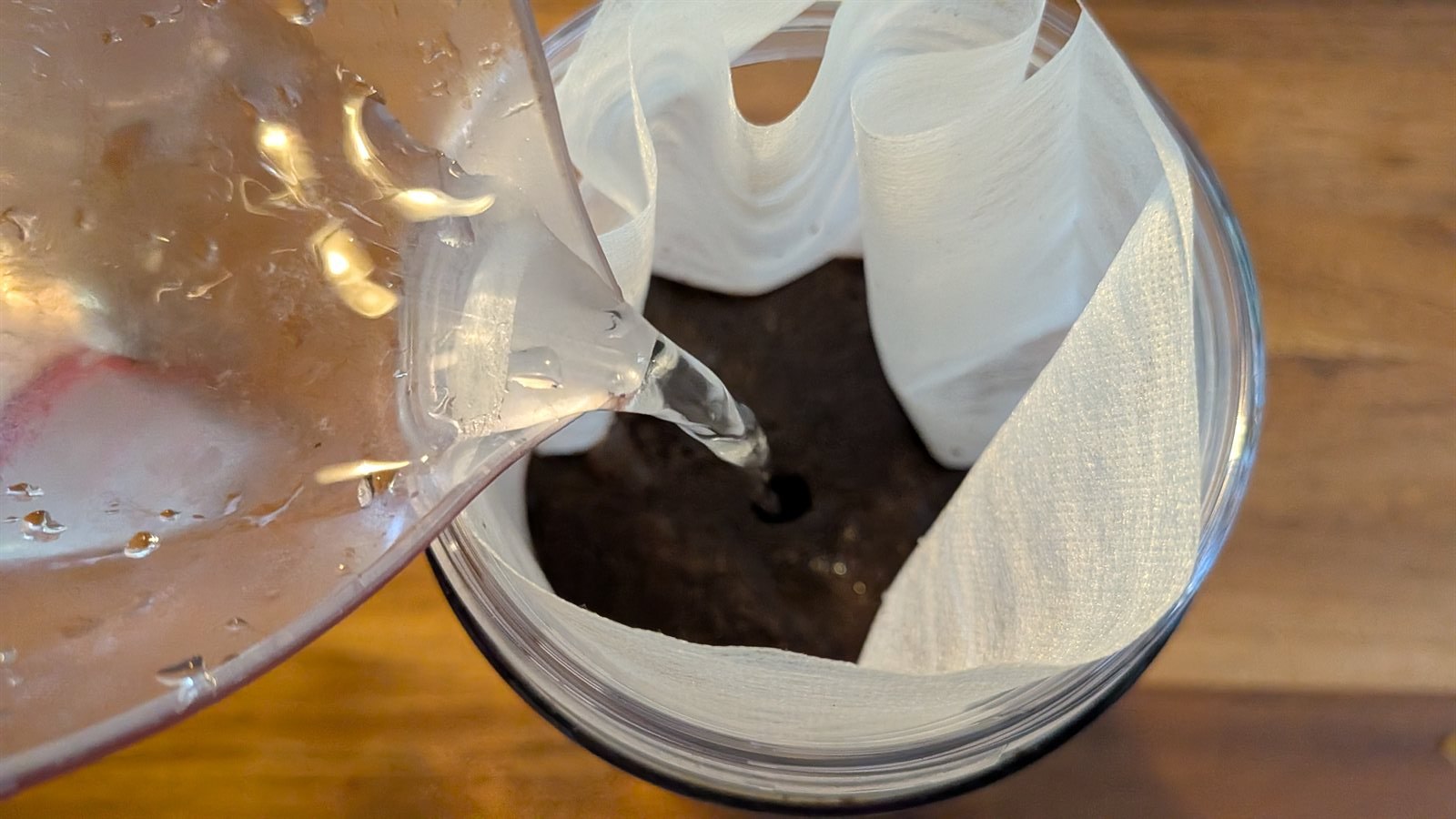 容器内に置いた不織布パックの中のコーヒー粉に、直接浄水を注いでいる様子